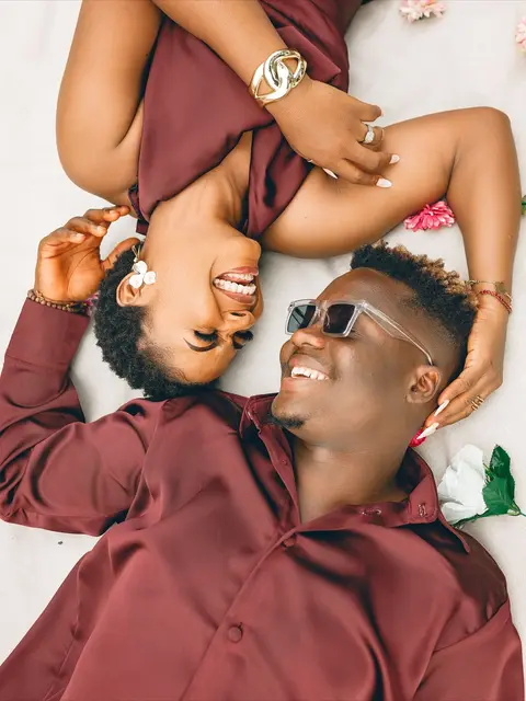 Wanandoa wamelala kichwa kwa kichwa, wakicheka pamoja